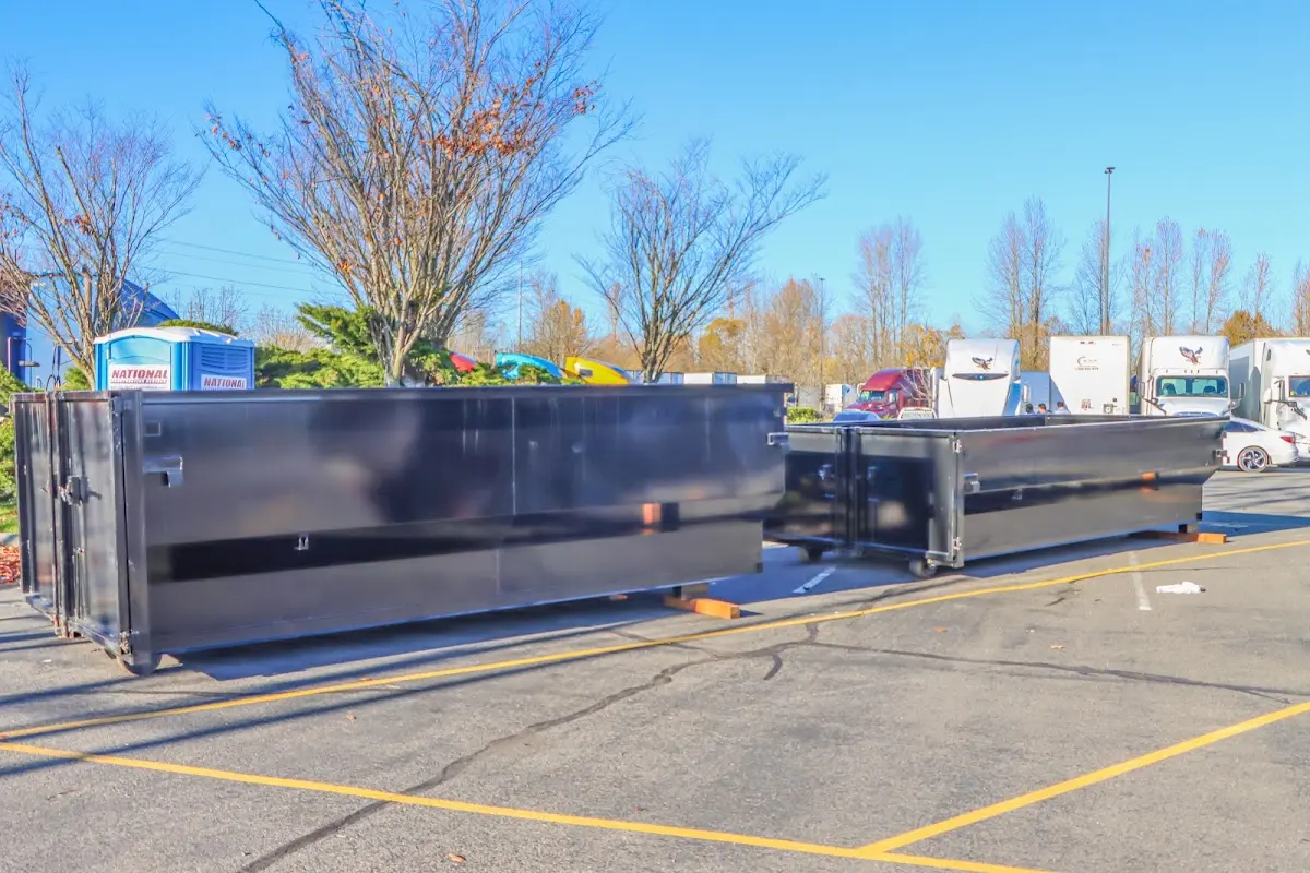 Professional dumpster rental service with roll-off container on residential driveway in St. James